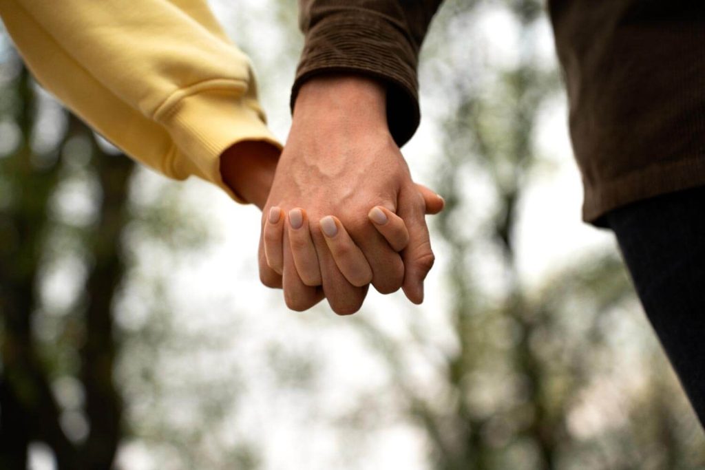 Close-up of a couple holding hands in Miami, Florida, symbolizing unity and support, representing the compassionate approach of Judith Ramos, Attorney at Law to alimony and spousal support cases.