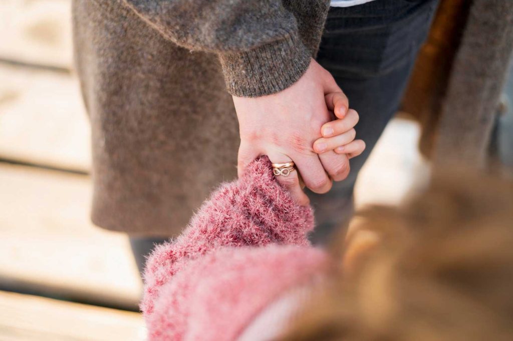 A close-up of a parent holding a child’s hand, representing emotional support and connection in child custody cases managed by Judith Ramos, Attorney at Law in Miami, Florida.